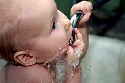 Малыш пьет воду из крана Малыш пьет воду из крана